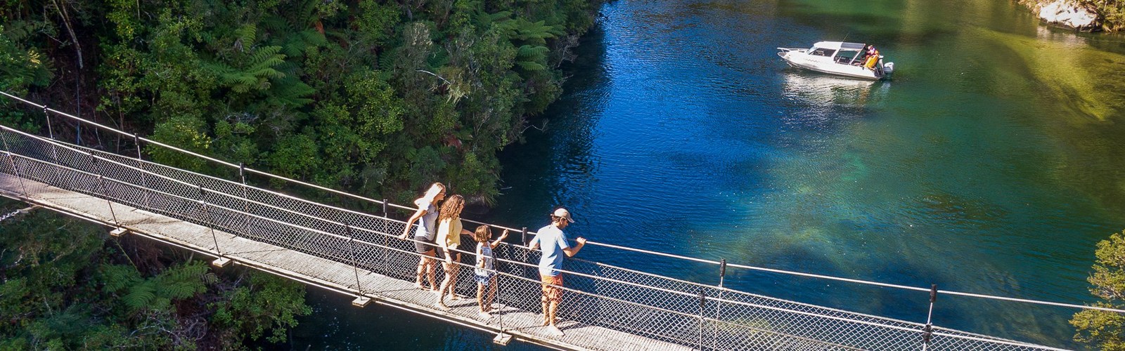 Falls Riverの吊り橋を歩く人たちと、下に広がる透明な青緑の水面