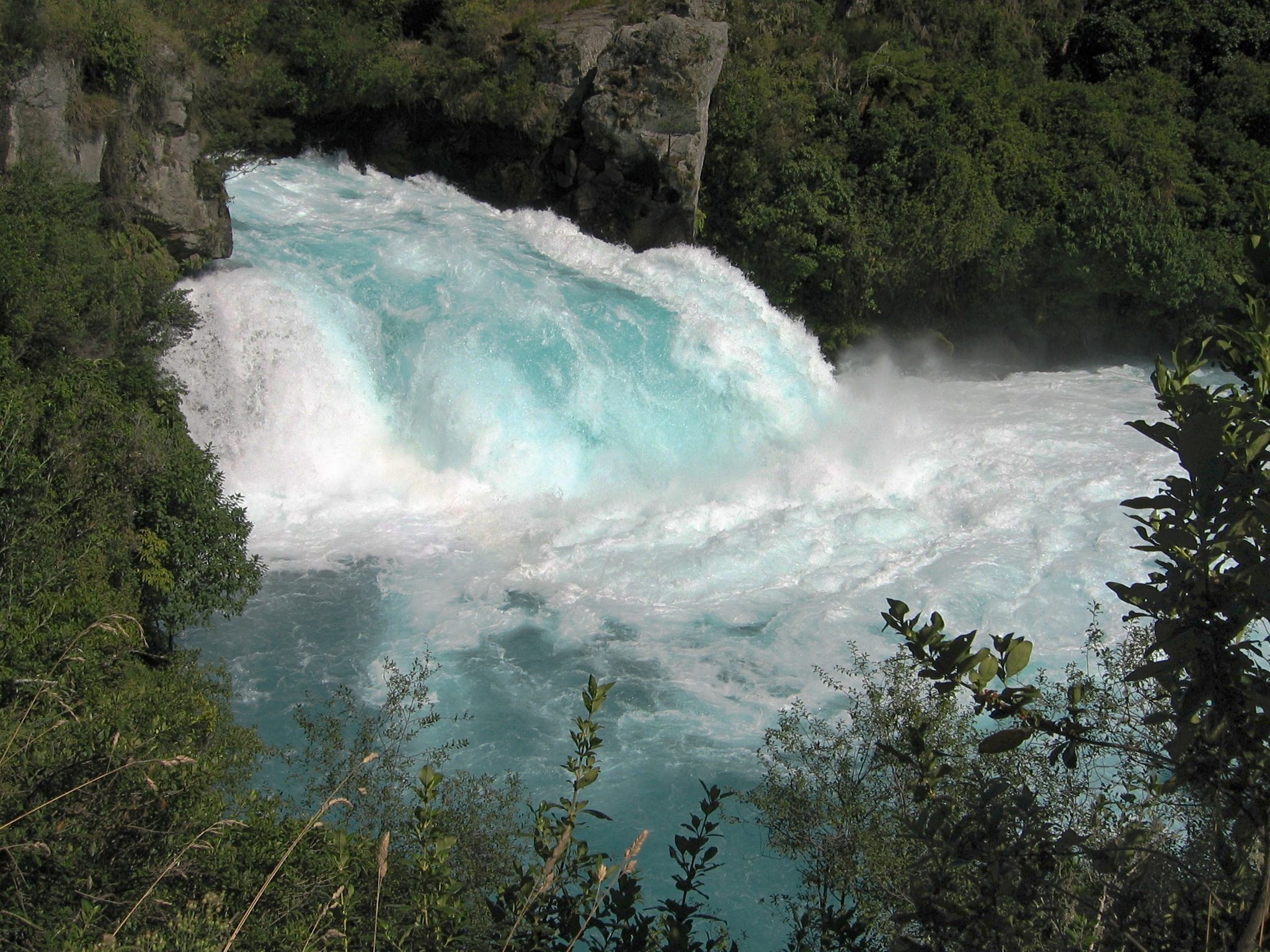 明るい青色の水が岩の間を流れ落ちるHuka Falls